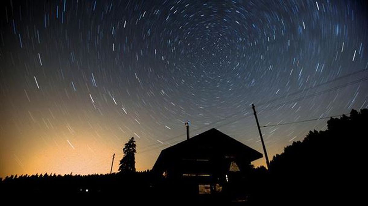 Un cielo estrellado con meteoros sobre una casa, en Austria
