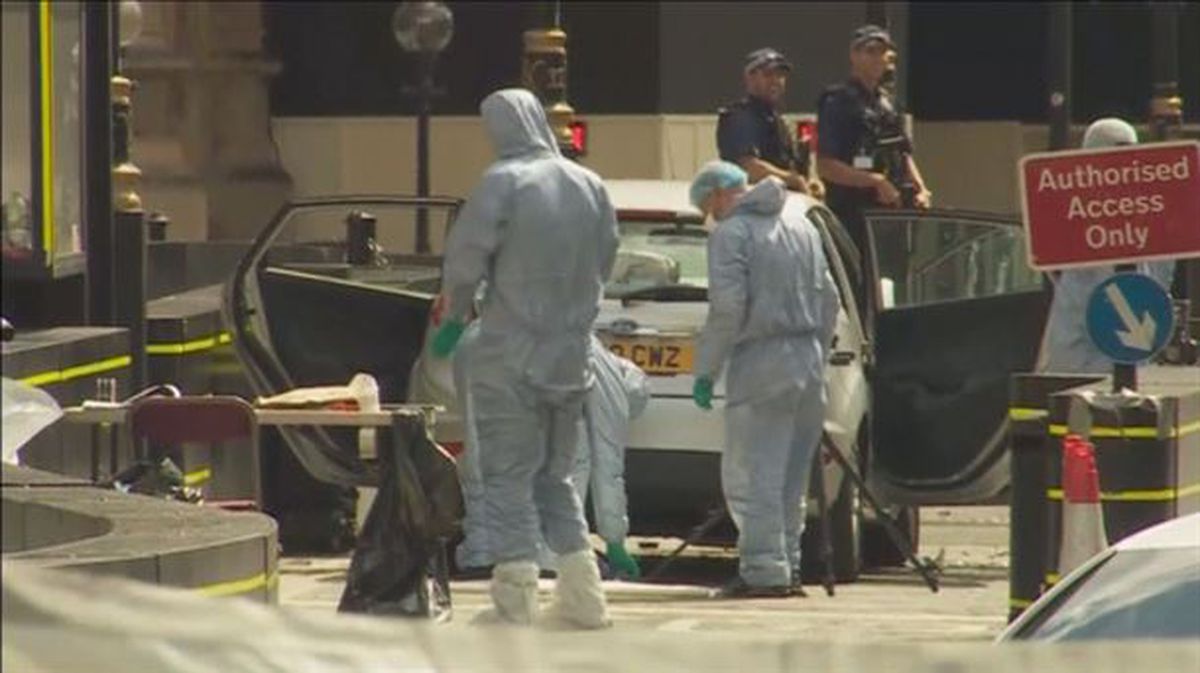 Los agentes analizando el coche del autor de los hechos. Foto: EFE