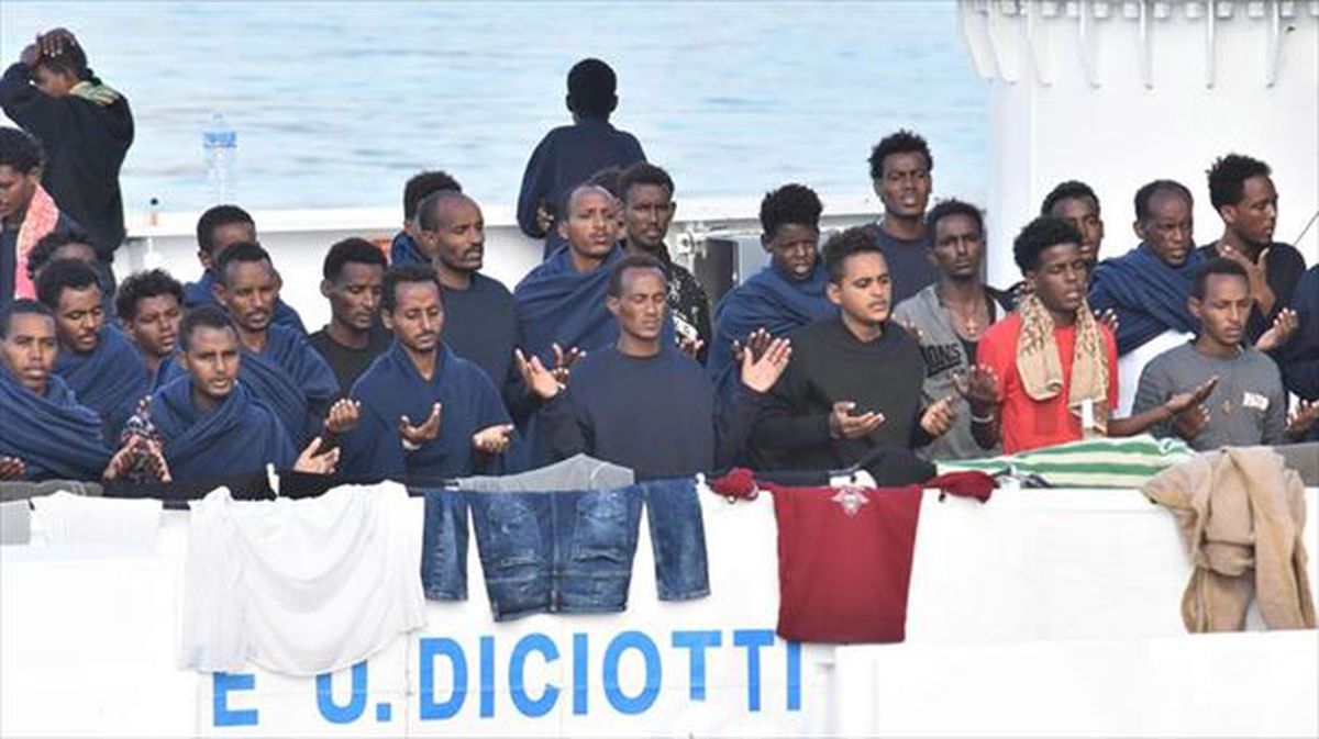 Los migrantes rezan a bordo del barco italiano Diciotti. Foto: EFE
