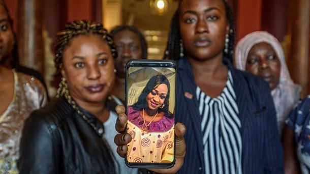 Dos mujeres muestran una foto de Maguette Mbeugou. Foto: EFE