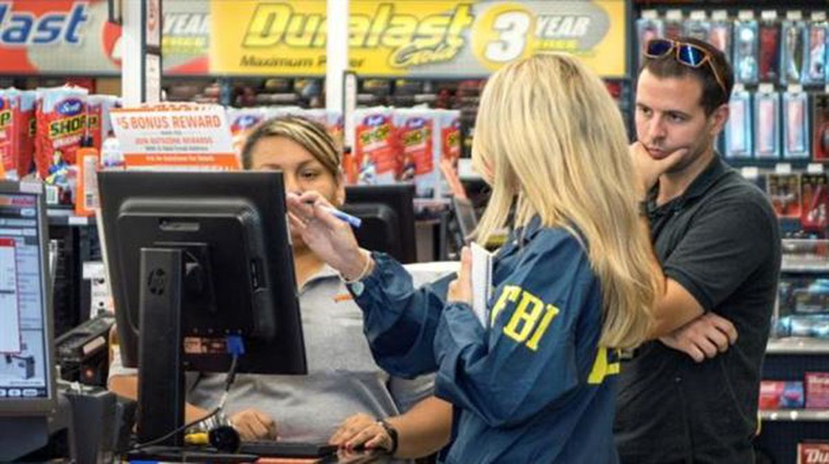 Agentes del FBI hablan con una empleada de la tienda Auto Zone en Plantation (Florida). Foto: EFE