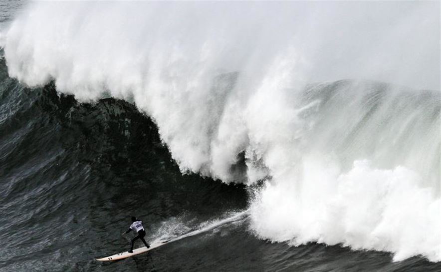 El surfista Pierre Rollet desciende una ola durante la XIII edición del Punta Galea Challenge, campeonato de surf de ola grande que se ha disputado hoy en Getxo