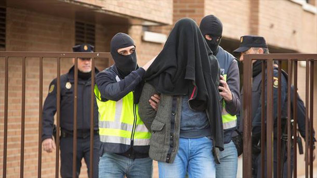 Un grupo de policías trasladando al detenido. 