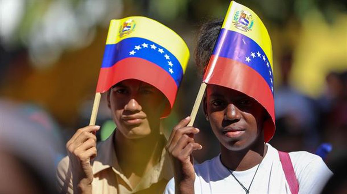 Maduroren aldeko bi pertsona, martxa batean parte hartzen