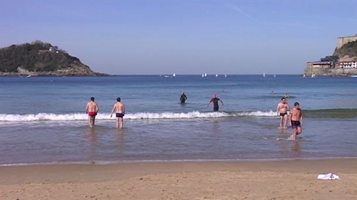 Varias personas se dan un chapuzón en la playa de La Concha en Donostia