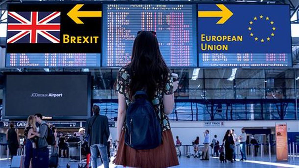Una mujer observa dos carteles con direcciones opuestas: UE o "brexit"