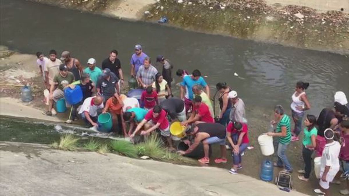 Venezolanos recogen agua del río Guaire