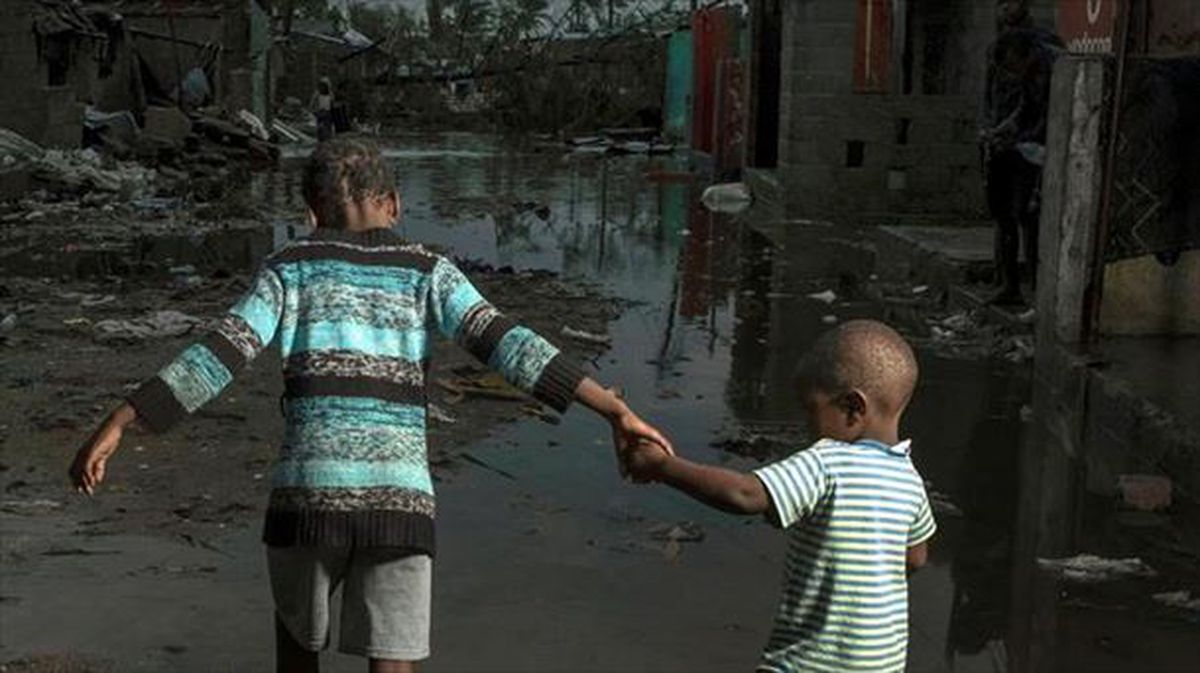 Dos niños cruzan una calle inundada en Mozambique.