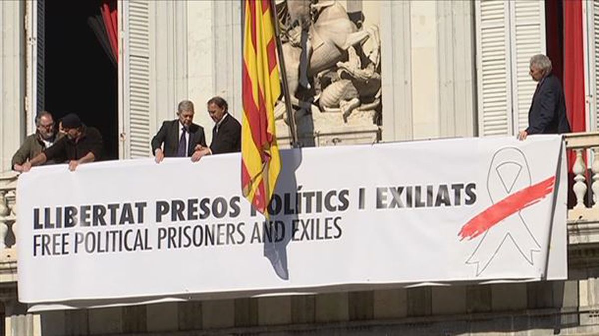 La nueva pancarta, con el lazo blanco, colgada en la fachada de la Generalitat