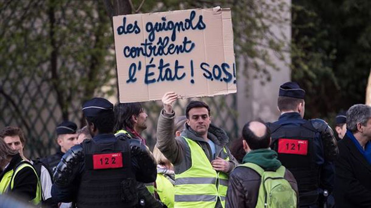 Gizon bat kartel bat erakusten manifestazio batean, Parisen. Argazkia: EFE/Christophe Petit Tesson