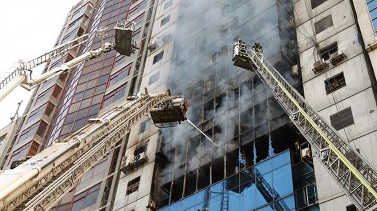 Bomberos tratan de sofocar un incendio en un edificio de Dacca.