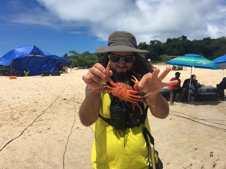 Un miembro del equipo de El Conquis sujeta a un cangrejo