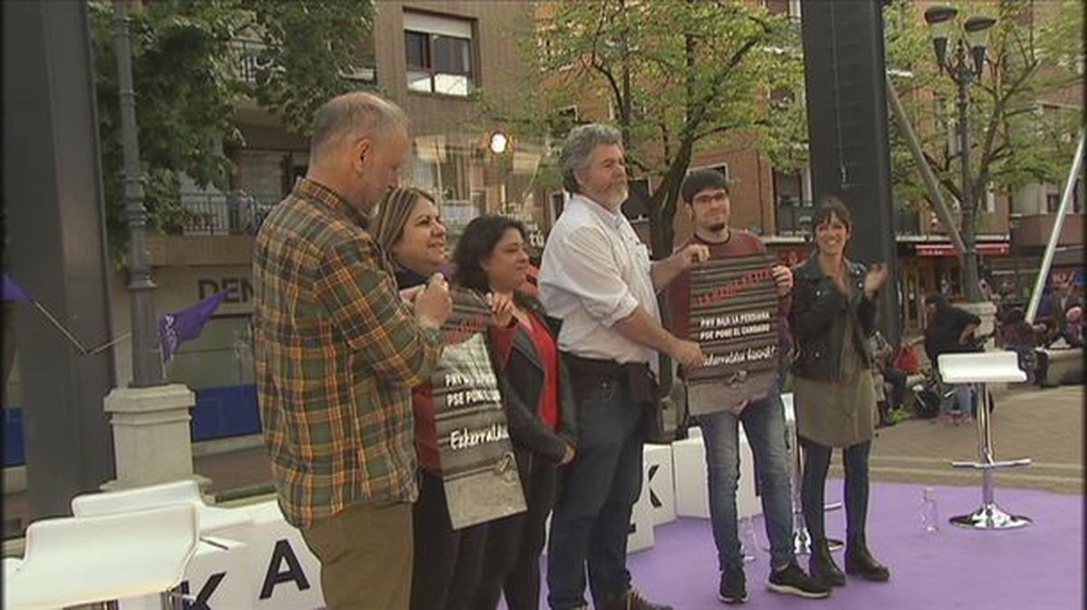 Candidatos de Elkarrekin Podemos sujetan carteles contra en cierre de La Naval en el acto de Sestao