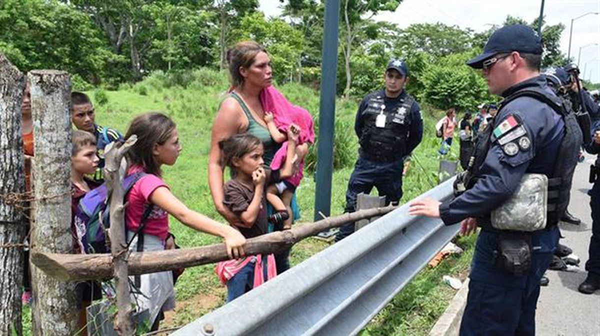 Policías intentan persuadir a una familia de migrantes centroamericanos