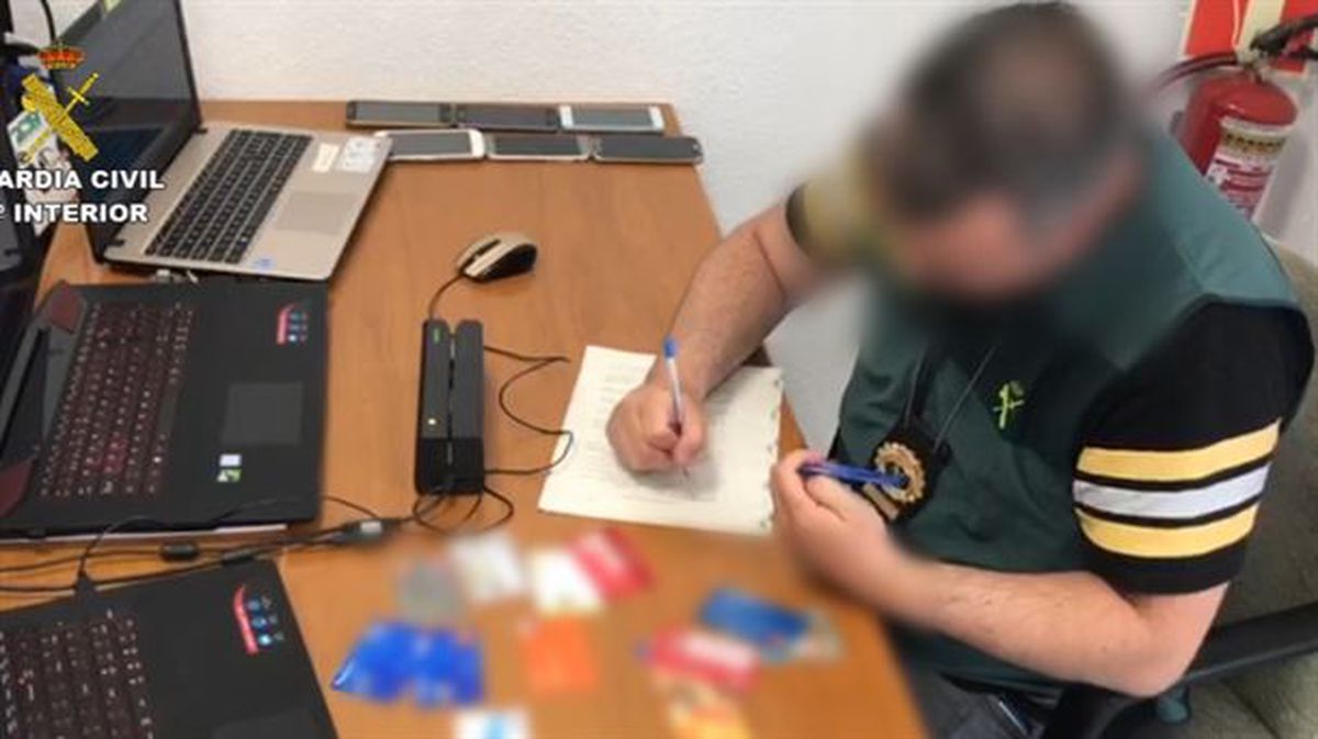 Un agente de la guardia civil, con las tarjetas falsificadas. 