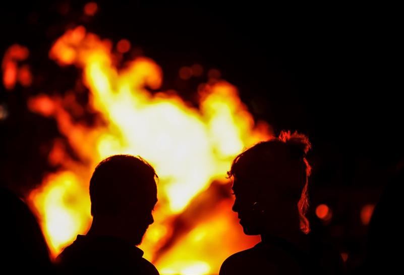 Dos personas frente a la hoguera de San Juan