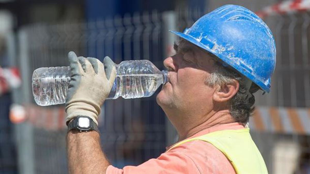Un operario bebe agua para hacer frente al calor. Foto de archivo: EFE
