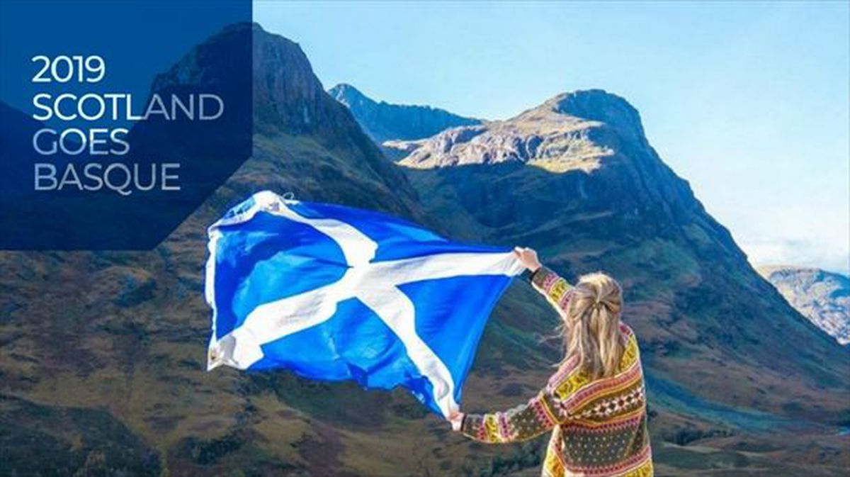 Una mujer sujetando la bandera de Escocia