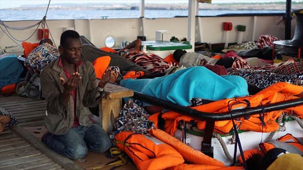 Un migrante reza en la cubierta del Open Arms