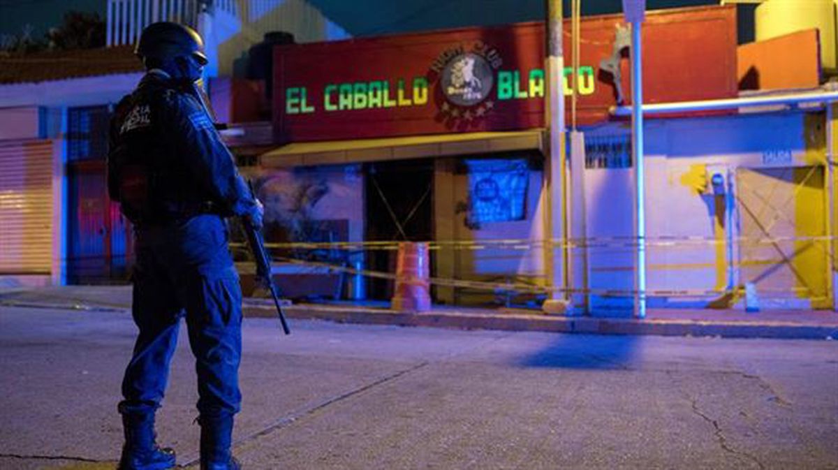 Un agente frente al bar El Caballo Blanco. 25 personas han muerto en un ataque con cócteles molotov
