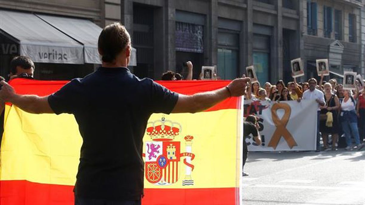 Un hombre muestra una bandera española a los manifestantes