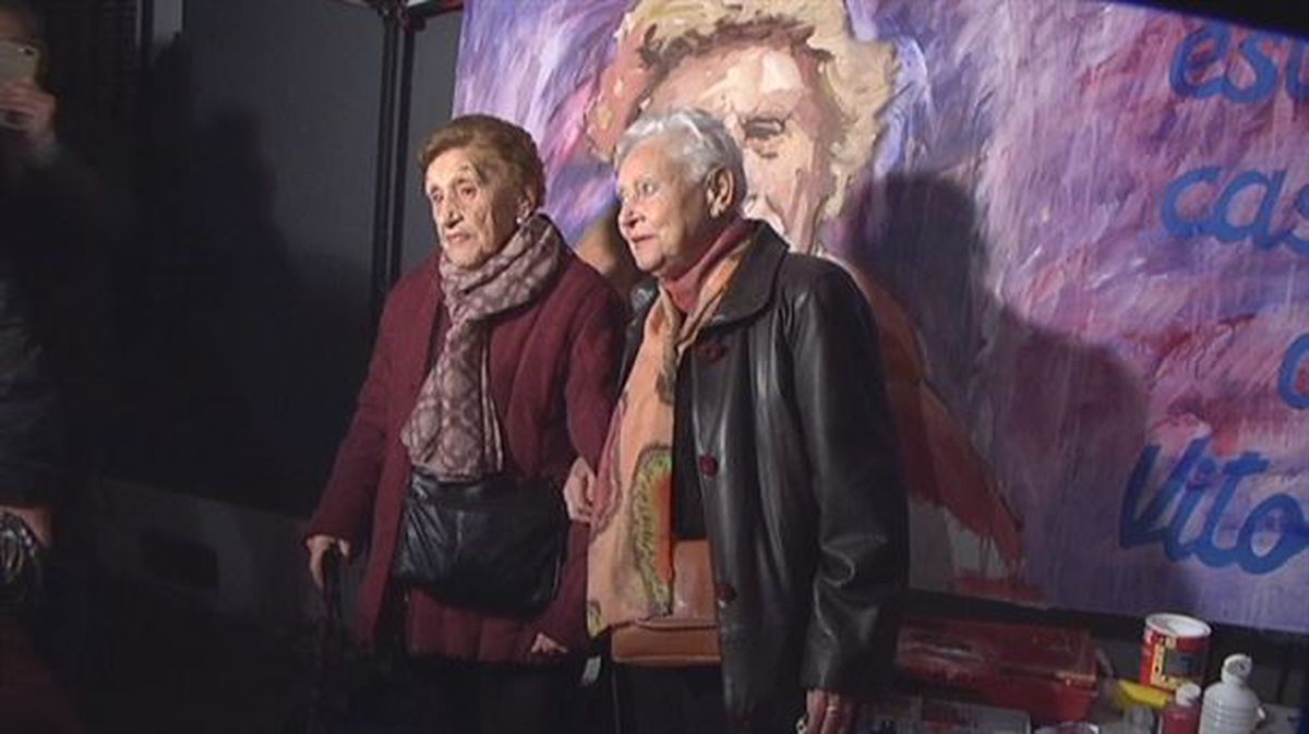 Vitori, junto a su hermana, delante de un mural con su rostro en Portugalete.