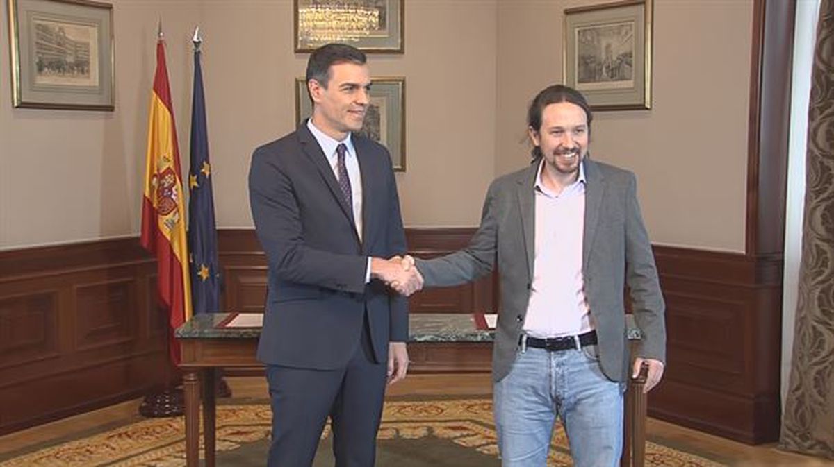 Pedro Sánchez y Pablo Iglesias, en la firma del acuerdo. Foto obtenida de un vídeo de agencias.