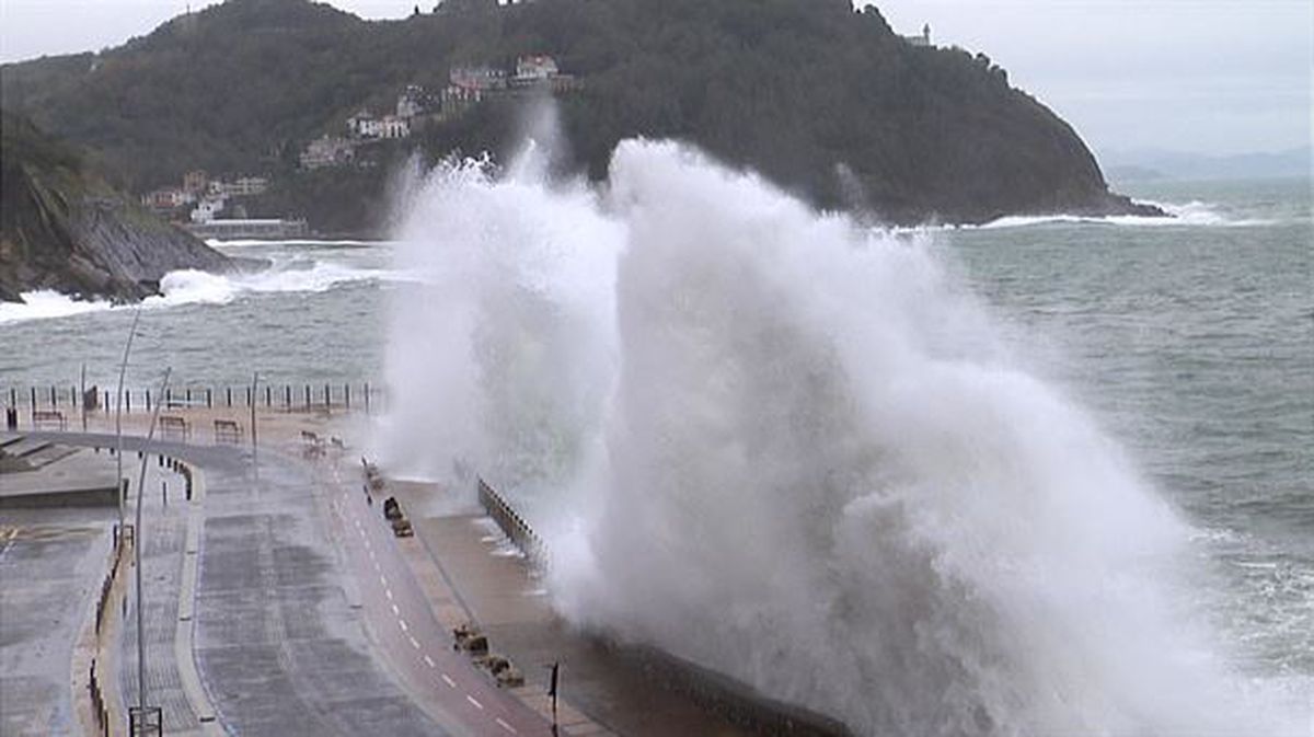 Varios surfistas observan la fuerza de las olas en la playa de Zarautz