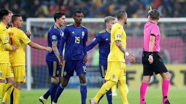 Isak se dirige al árbitro del partido, rodeado de jugadores de Suecía y de Rumanía