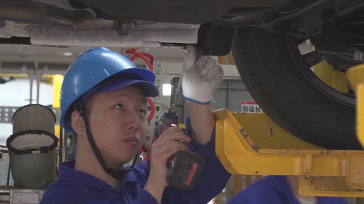 Imagen de un trabajador de una fábrica china que crea vehículos eléctricos