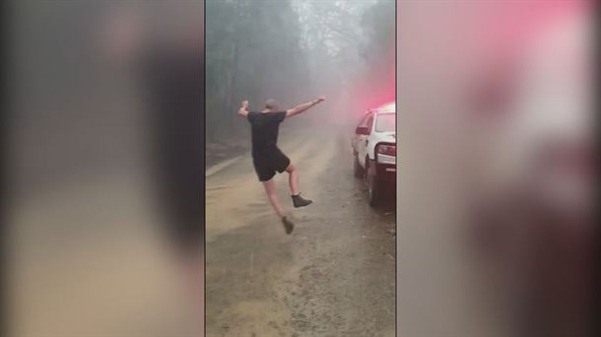 Un bombero baila bajo la lluvia