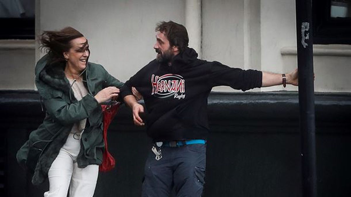 Dos personas hacen frente al fuerte viento en San Sebastián. 