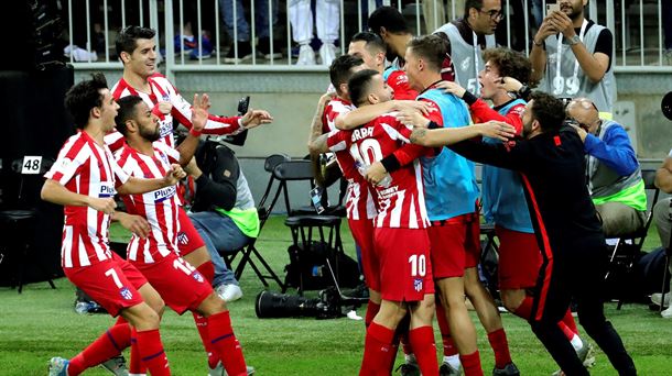 Jugadores del Atlético de Madrid celebran abrazados un gol.