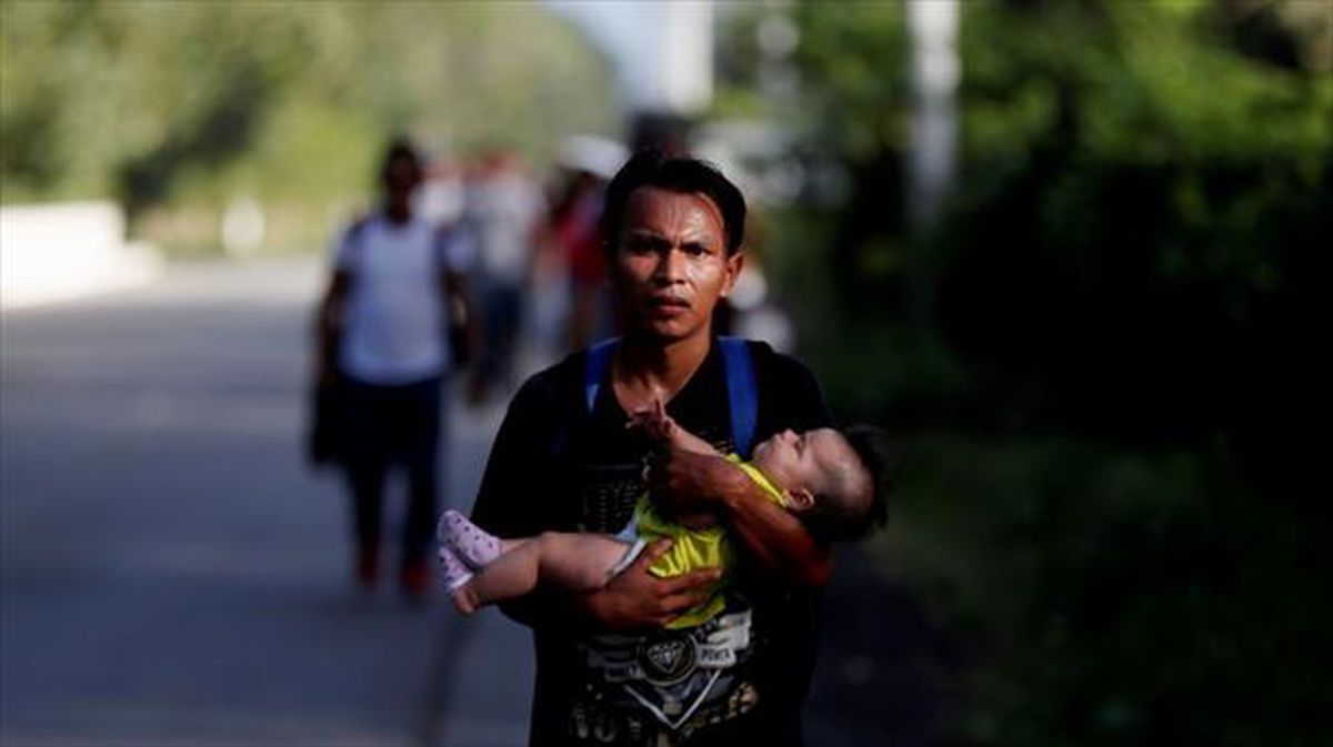 Un migrante con su hija en brazos