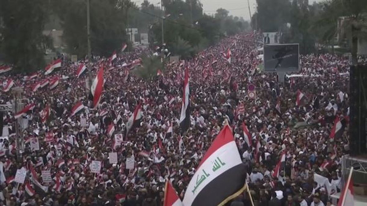 Manifestari bat, Irakeko bandera ontzen, Bagdaden egindako protestan. 