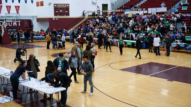 Varias personas se registran en el caucus en el instituto Lincoln de De Moines 