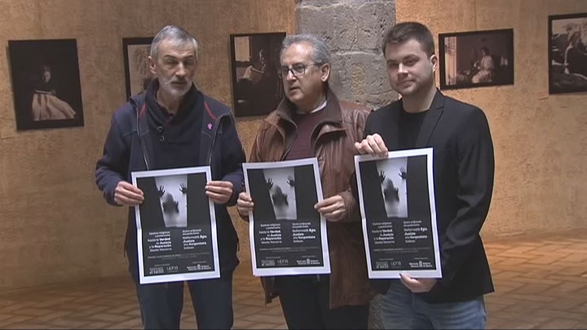 Los organizadores, UPNA, Gobierno de Navarra y asociación de víctimas, con el cartel en la mano