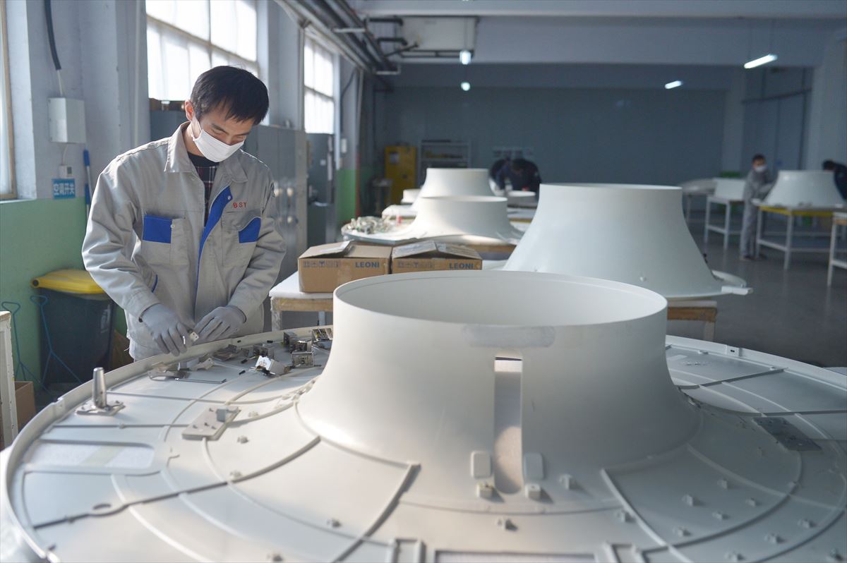 Un trabajador trabaja en la fabricación de la cubierta de plástico de un escáner