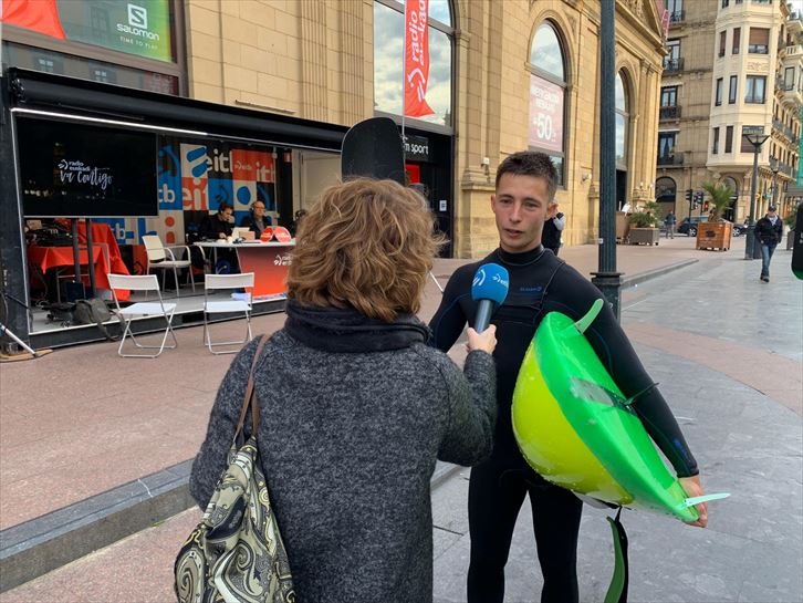 Surfer con la tabla a cuestas por la calles de Donostia