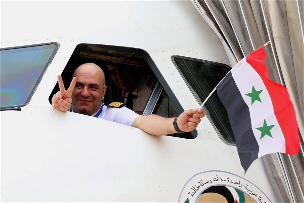 Un piloto ondea una bandera siria