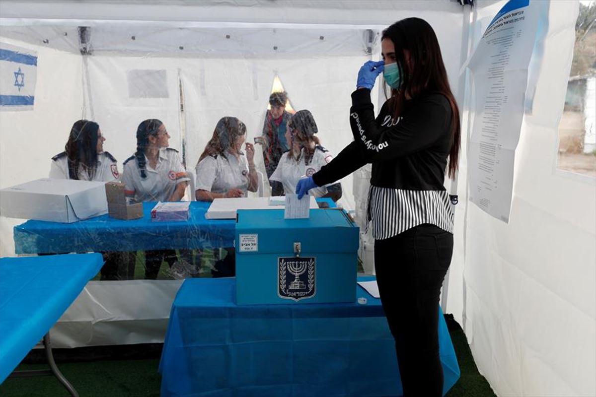 Una persona vota en Israel en una cabina preparada para personas en cuarentena por el coronavirus