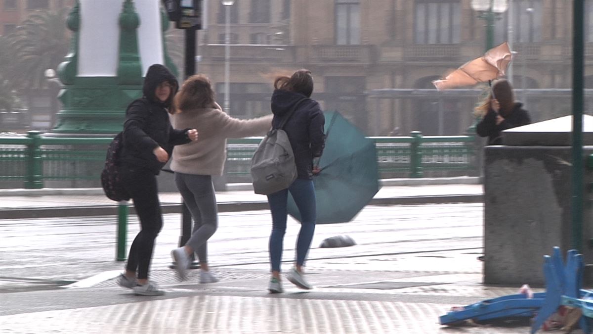 Jóvenes luchando contra el viento en San Sebastián.