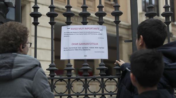 Una mujer y dos niños en la entrada de un colegios de Bilbao.