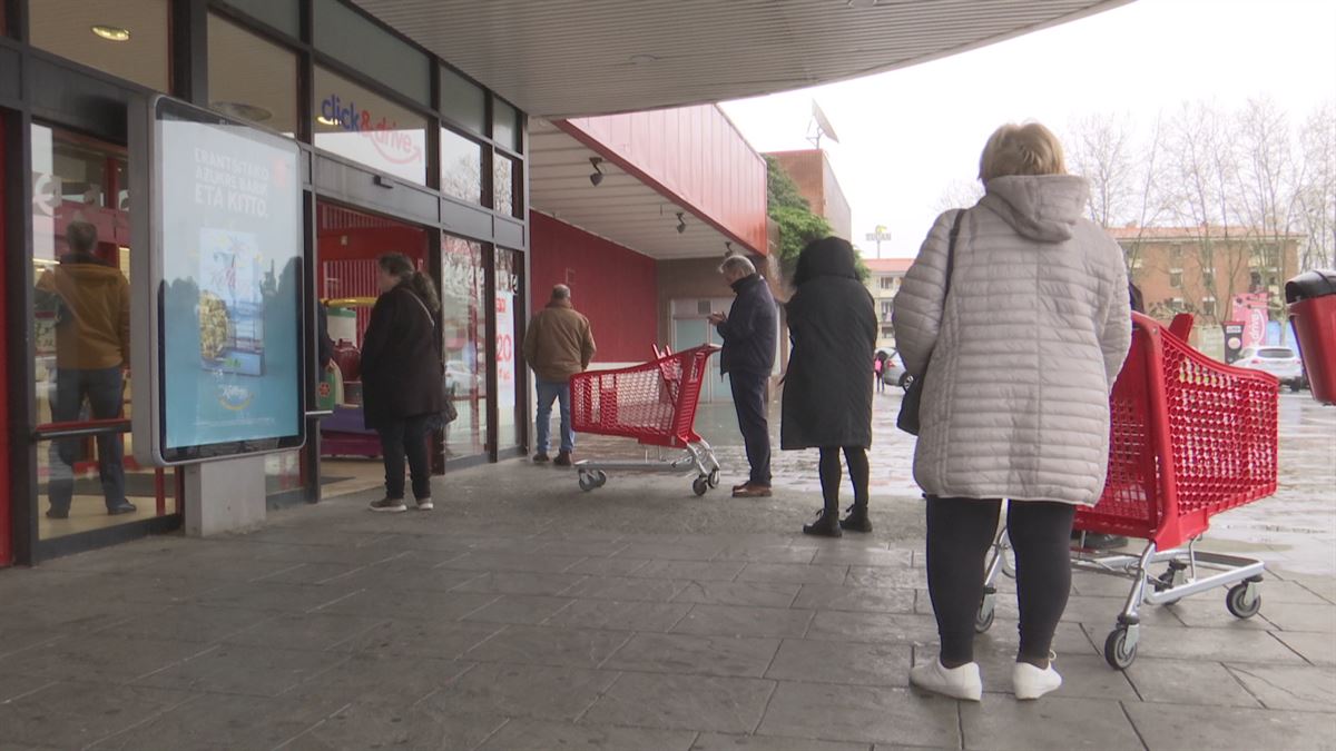 Consumidores esperan para poder acceder a un supermercado