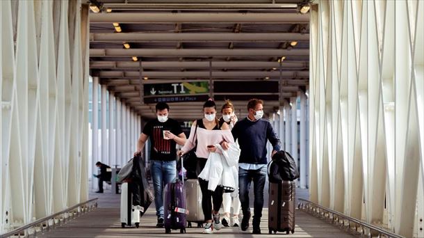 Varios pasajeros protegidos con mascarillas en el aeropuerto de Barcelona 