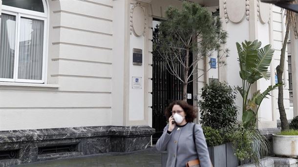 Una mujer con mascarilla camina frente al Hotel Calton de Bilbao.