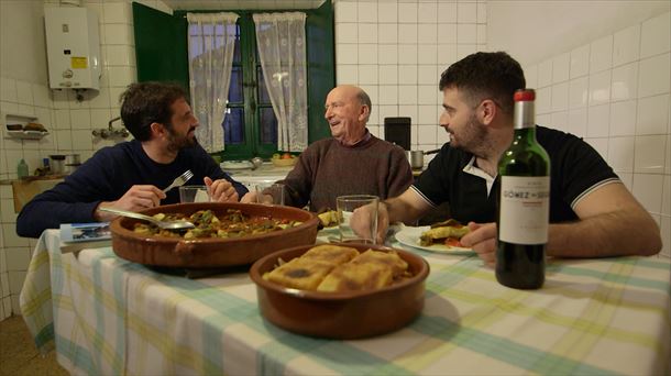 Joseba Arguiñano charlando con dos vecinos de Olabe mientras están comiendo en la cocina