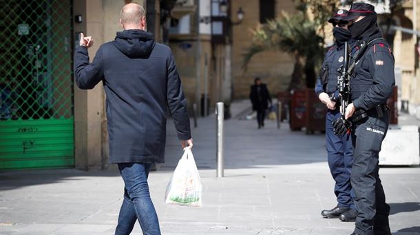 Dos ertzainas preguntan a un peatón en San Sebastián.