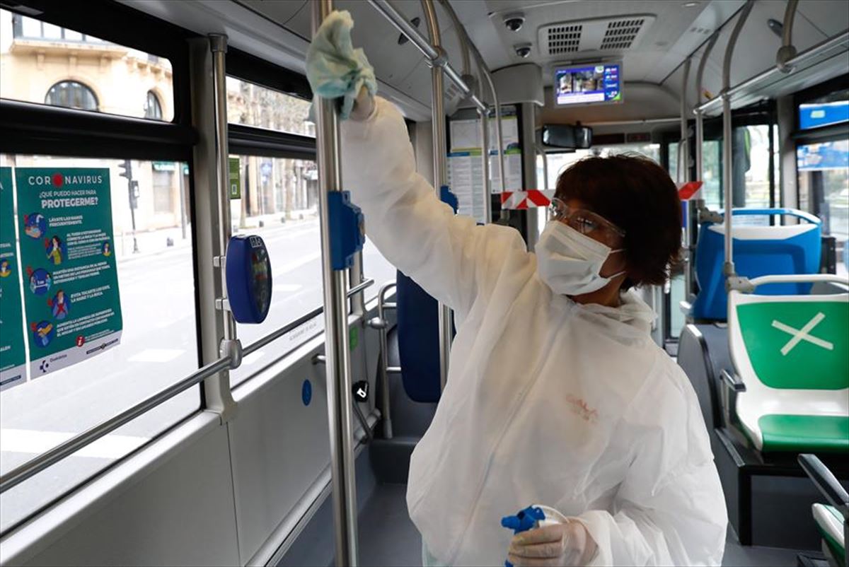 Una trabajadora de la limpieza limpia el interior de un autobús