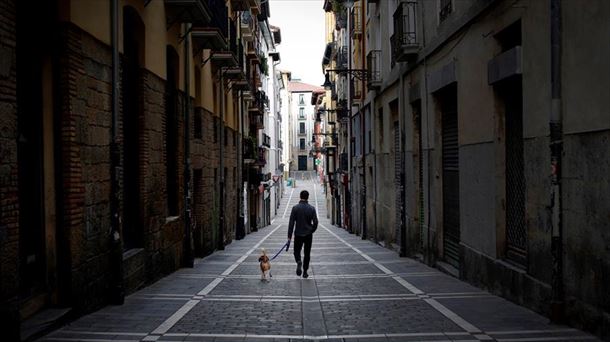 Un hombre pasea junto a su perro por Pamplona.